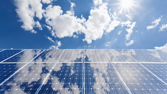 Solar panels shining under bright sky