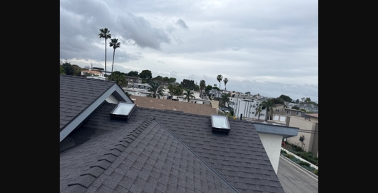 Finished charcoal architectural shingle roof in Manhattan Beach under an overcast gray sky — BYLTup