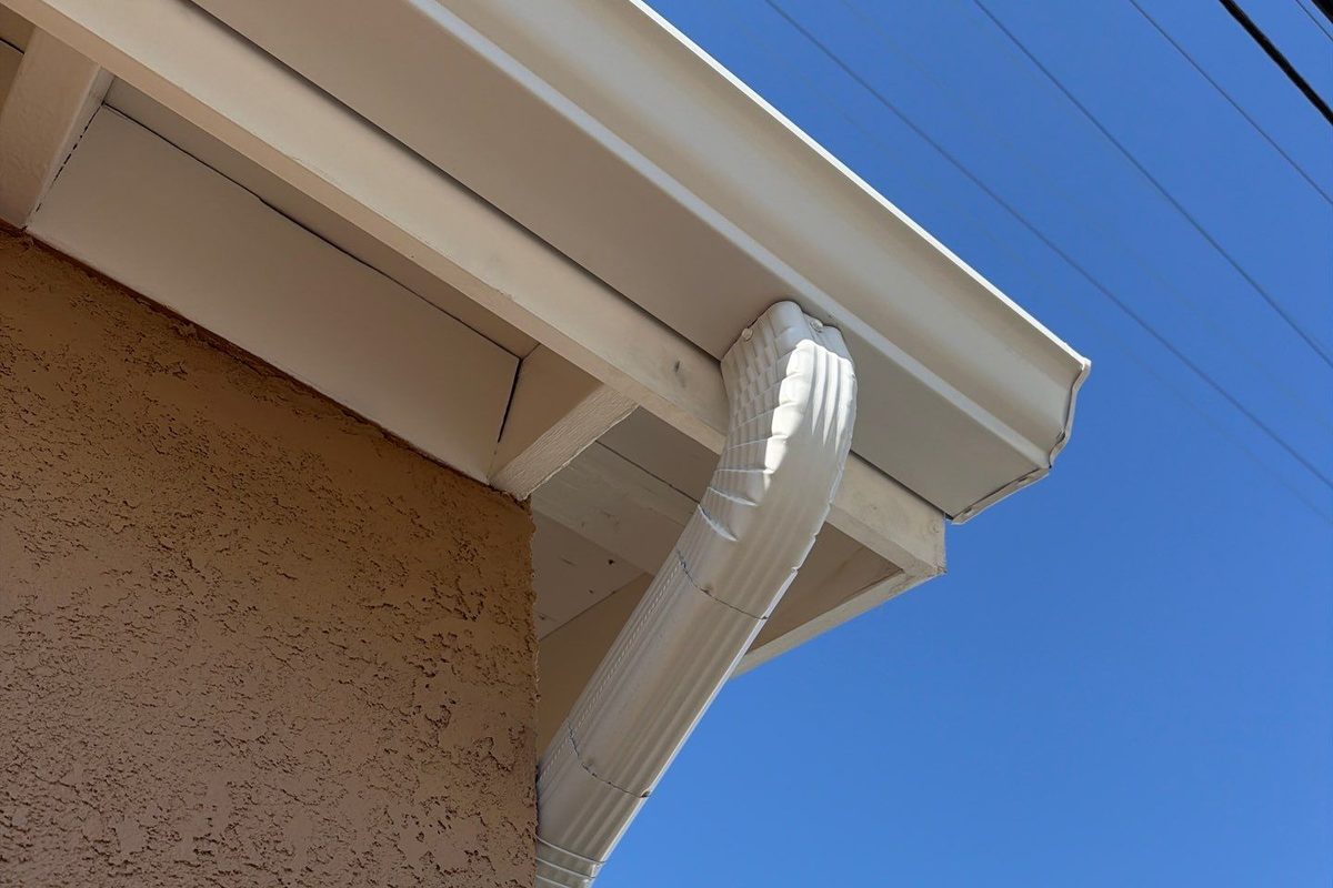 White fascia board with a seamless gutter and downspout on a Lakewood home
