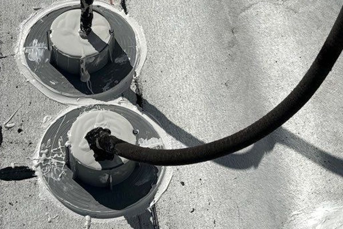 Two sealant-filled pitch pockets around conduit on a Long Beach commercial flat roof
